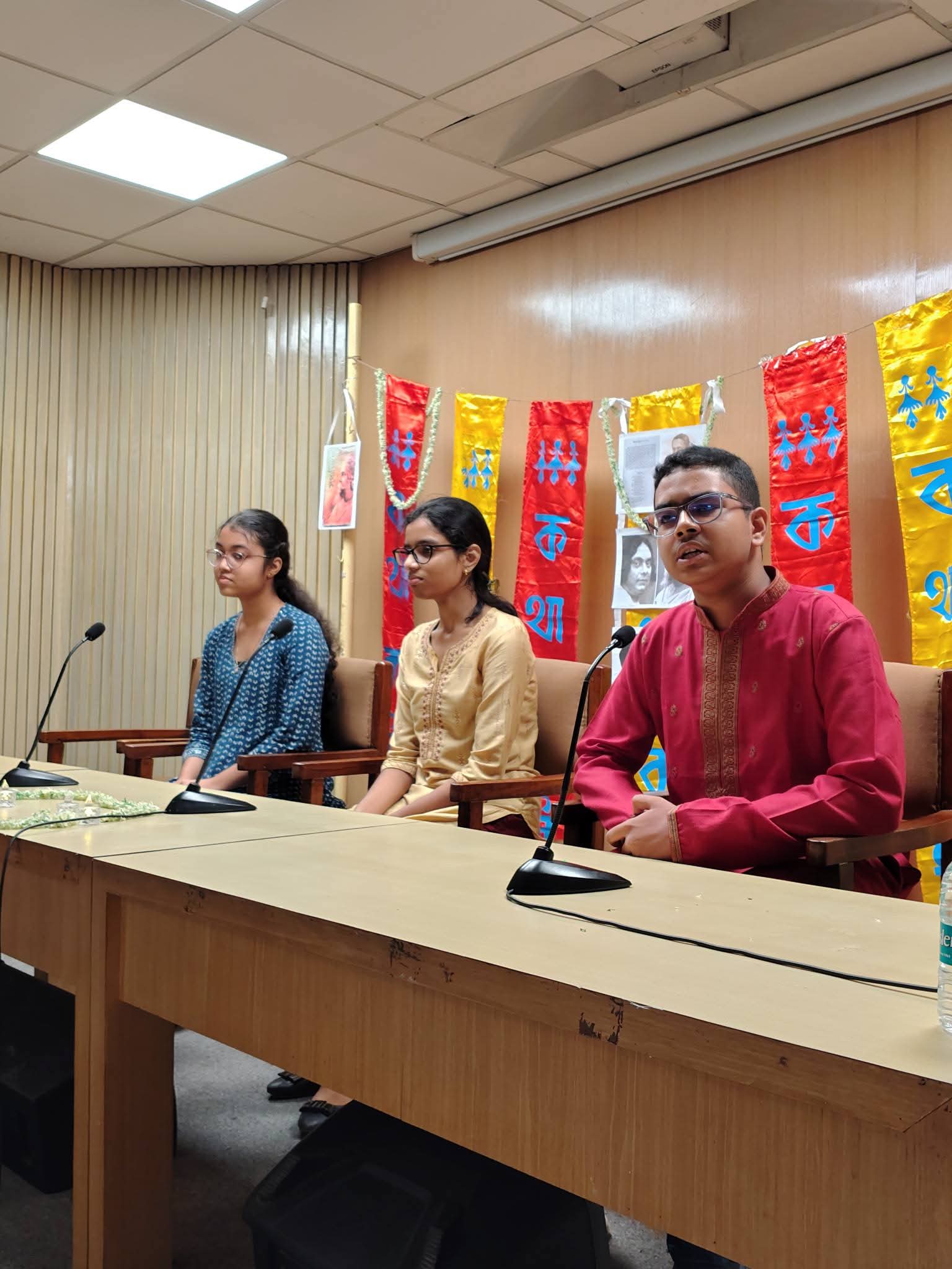 Students speaking into microphones at the programme