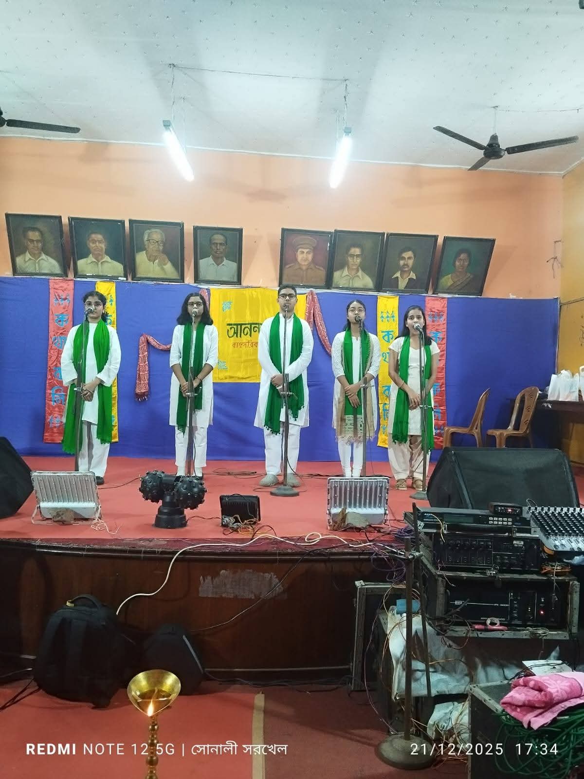 Young students in traditional attire performing on stage